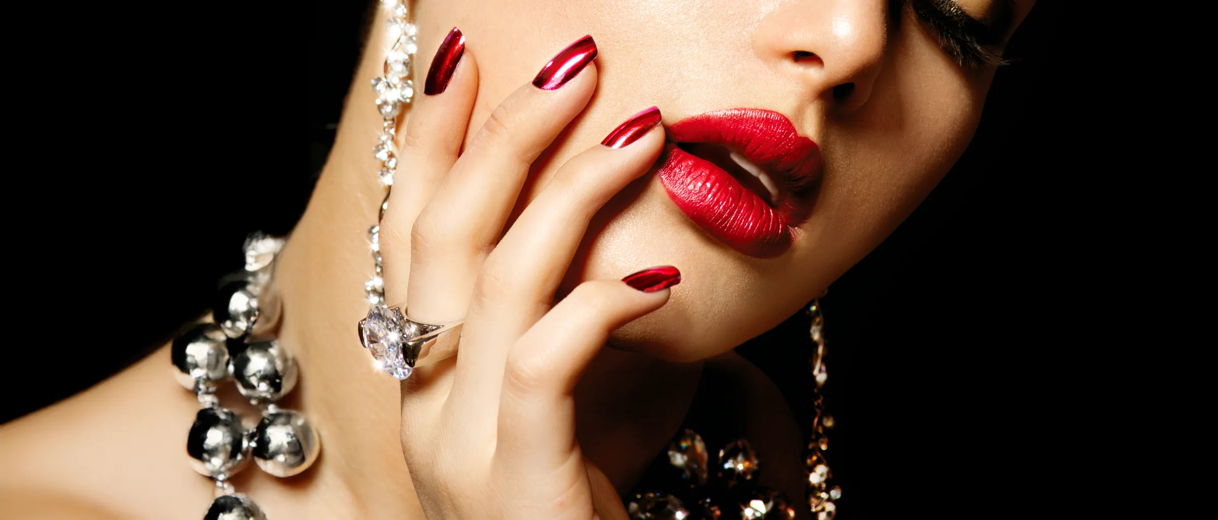 Deep red manicure framed against a dark backdrop