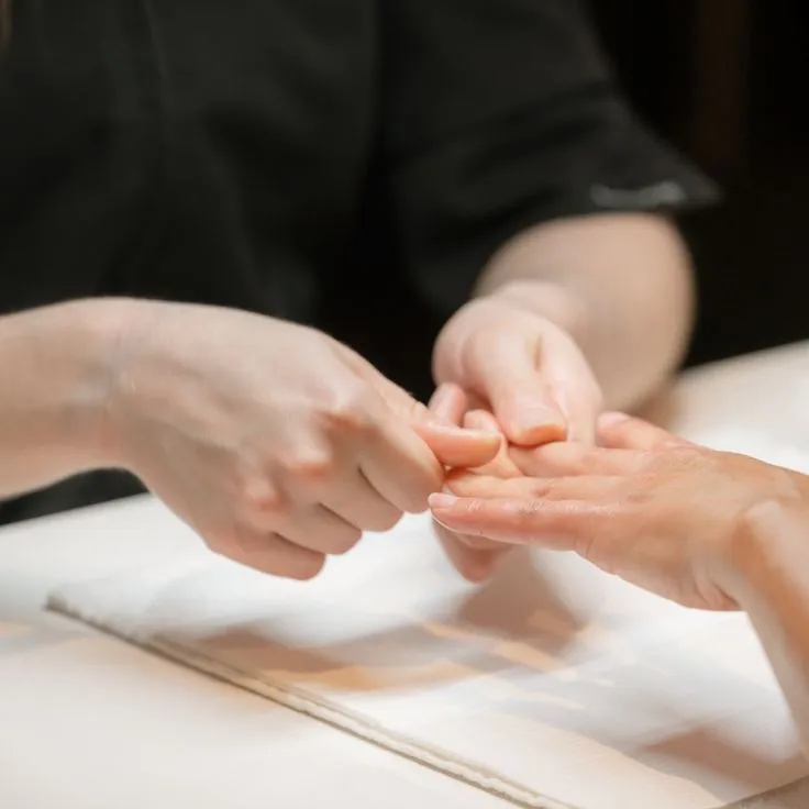 Hands resting on a towel during a manicure