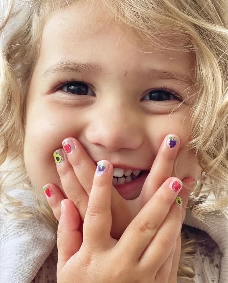 A delighted child showing freshly painted nails